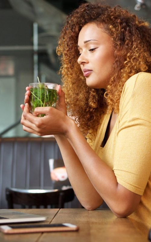 attractive-young-woman-sitting-at-cafe-drinking-tea.jpg